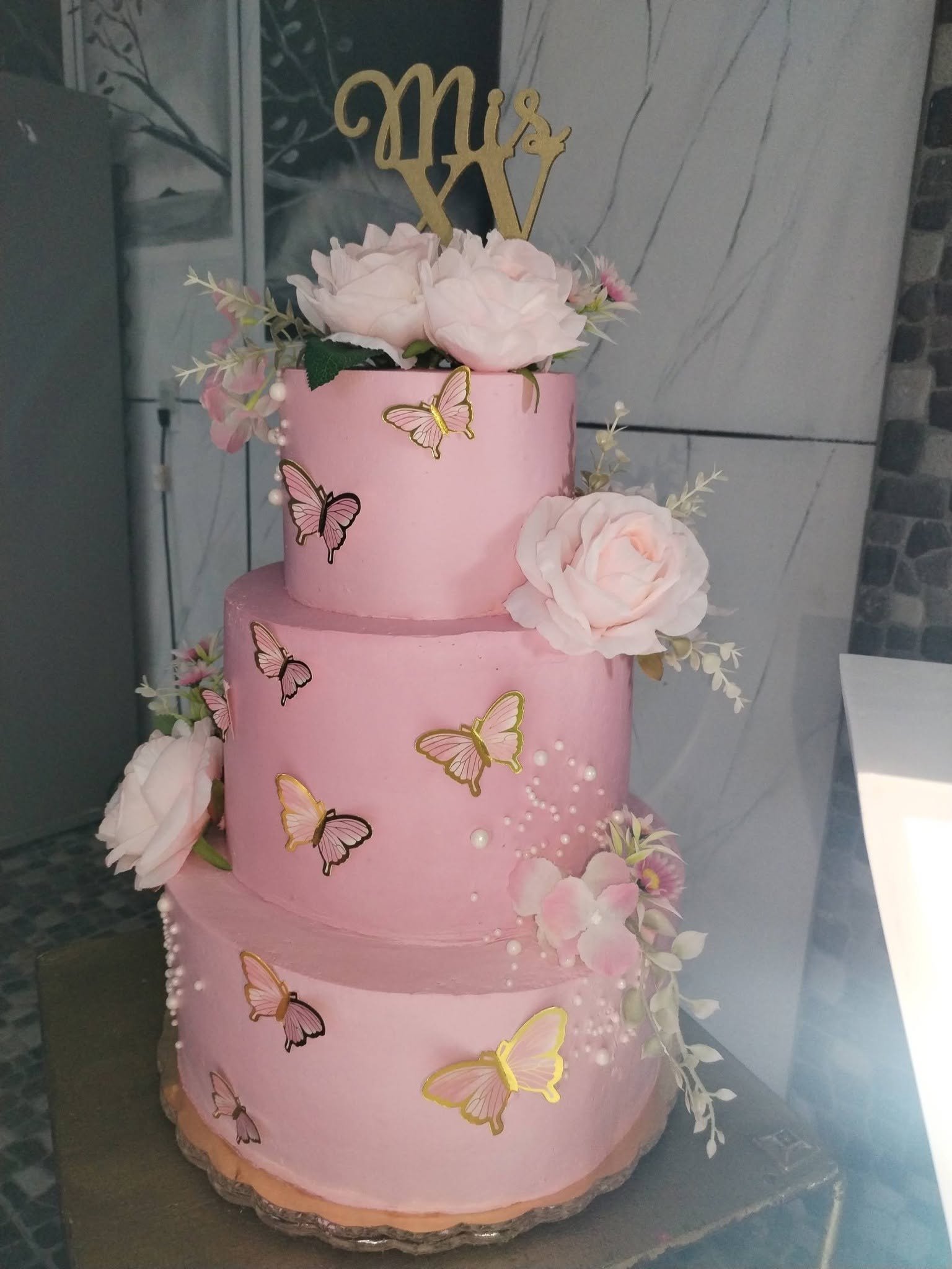 Pastel personalizado rosa de tres pisos con flores y mariposas